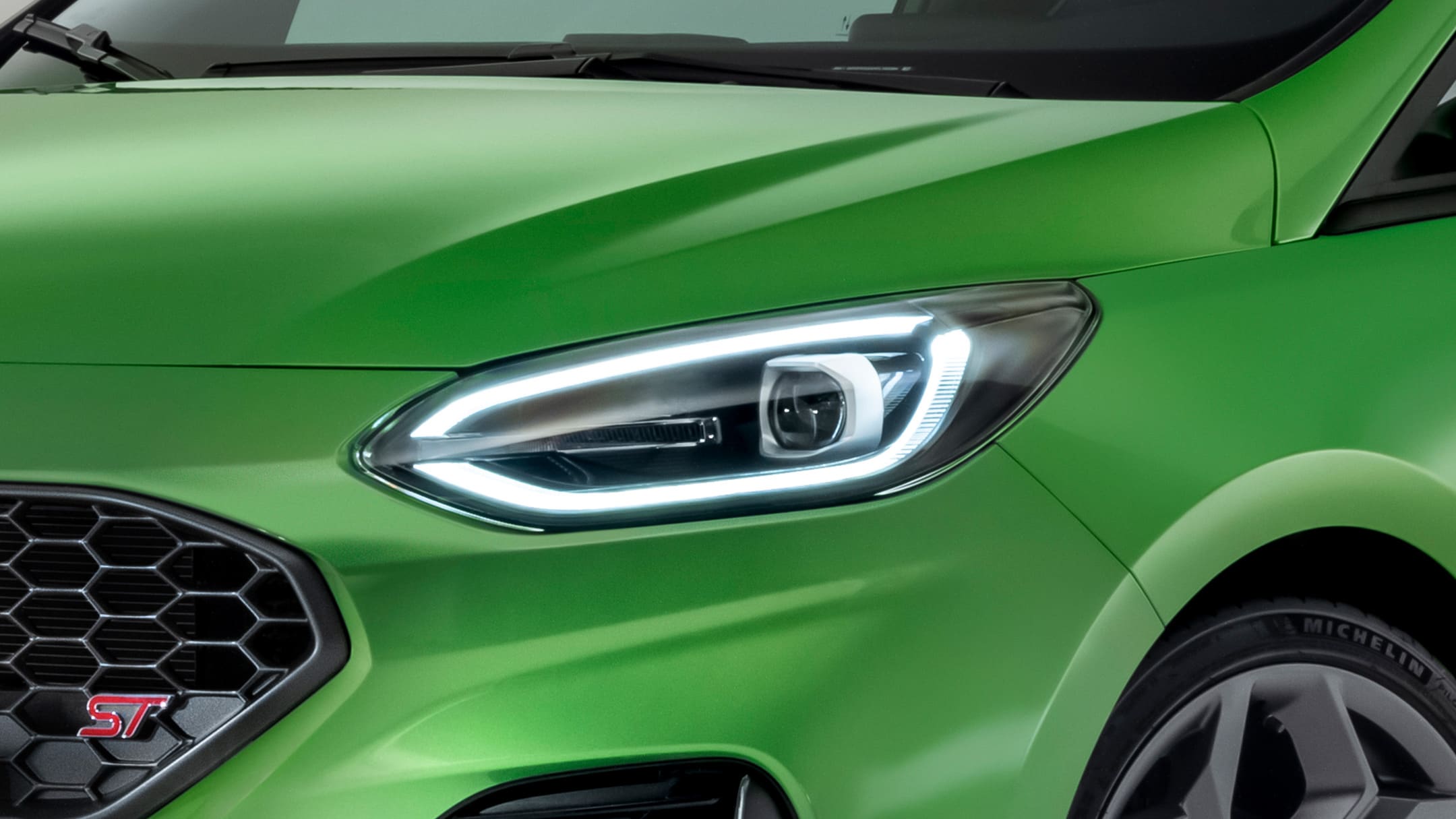 Ford Fiesta ST verde. Vista dettagliata di un faro anteriore.