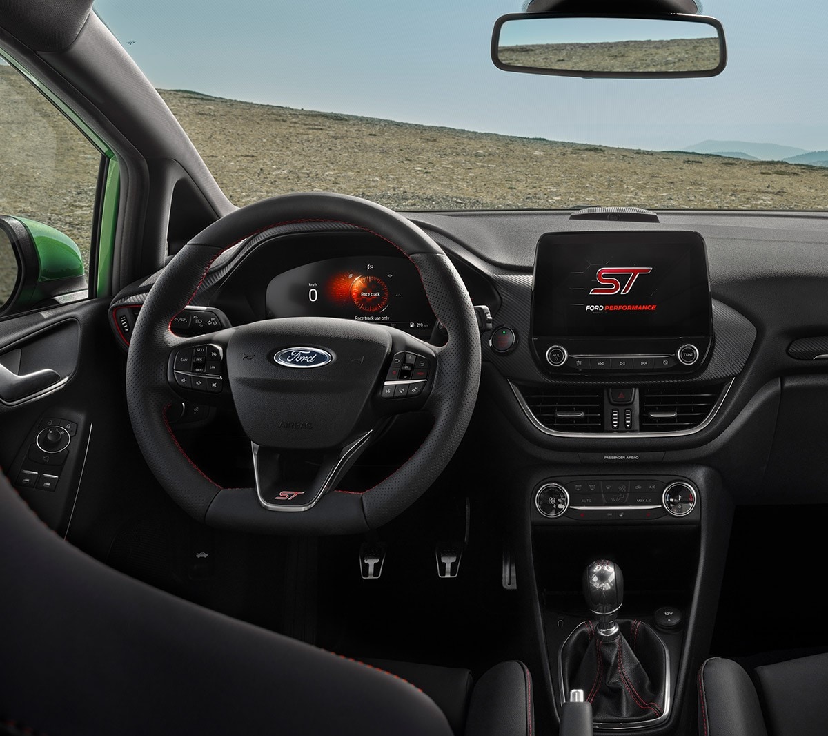Ford Fiesta ST. Vista interna sul cockpit con volante, touchscreen e quadro strumenti digitale.