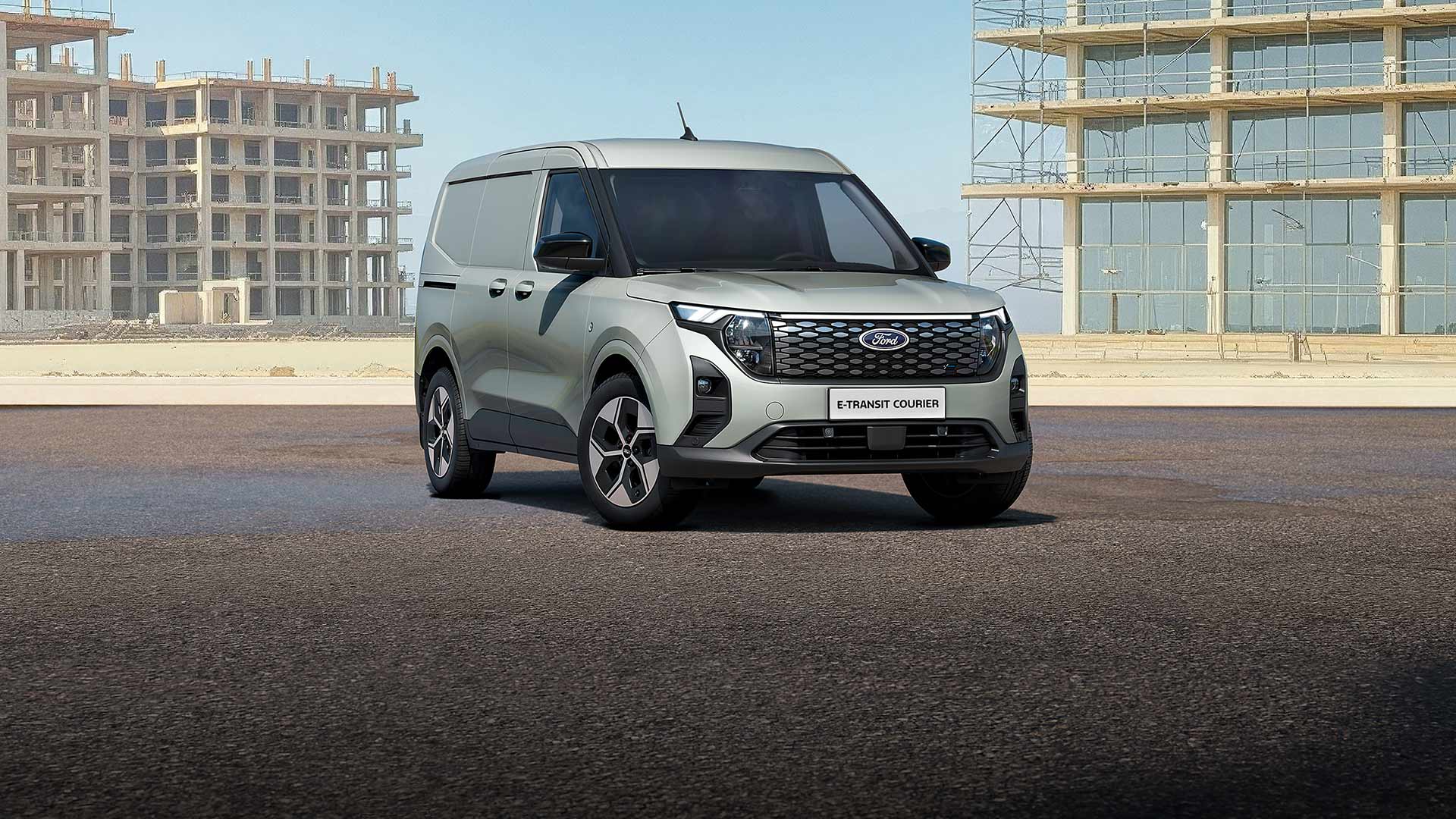 Un Ford E-Transit Courier grigio parcheggiato su una strada.