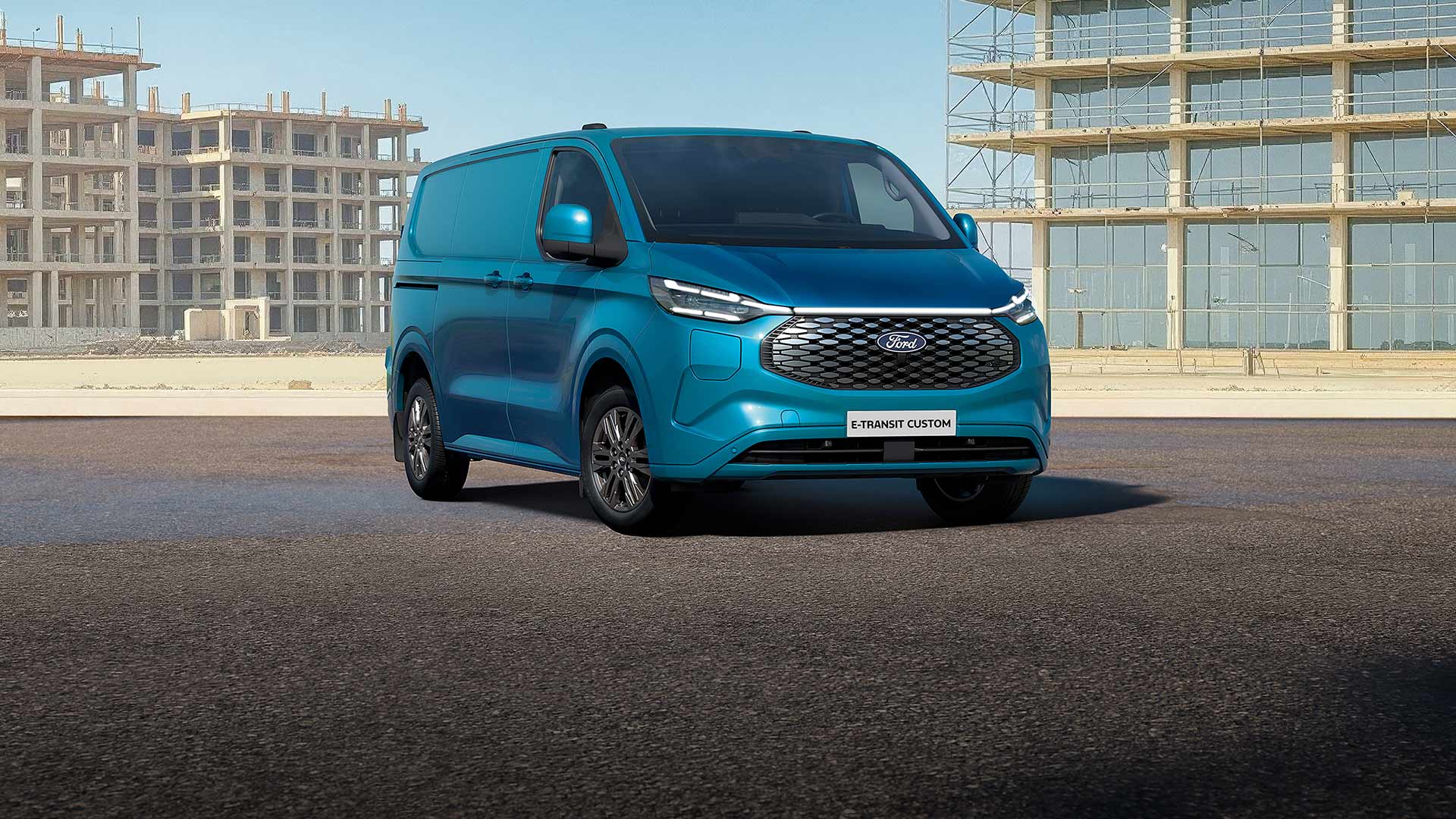 Un Ford E-Transit Custom blu parcheggiato su una strada.