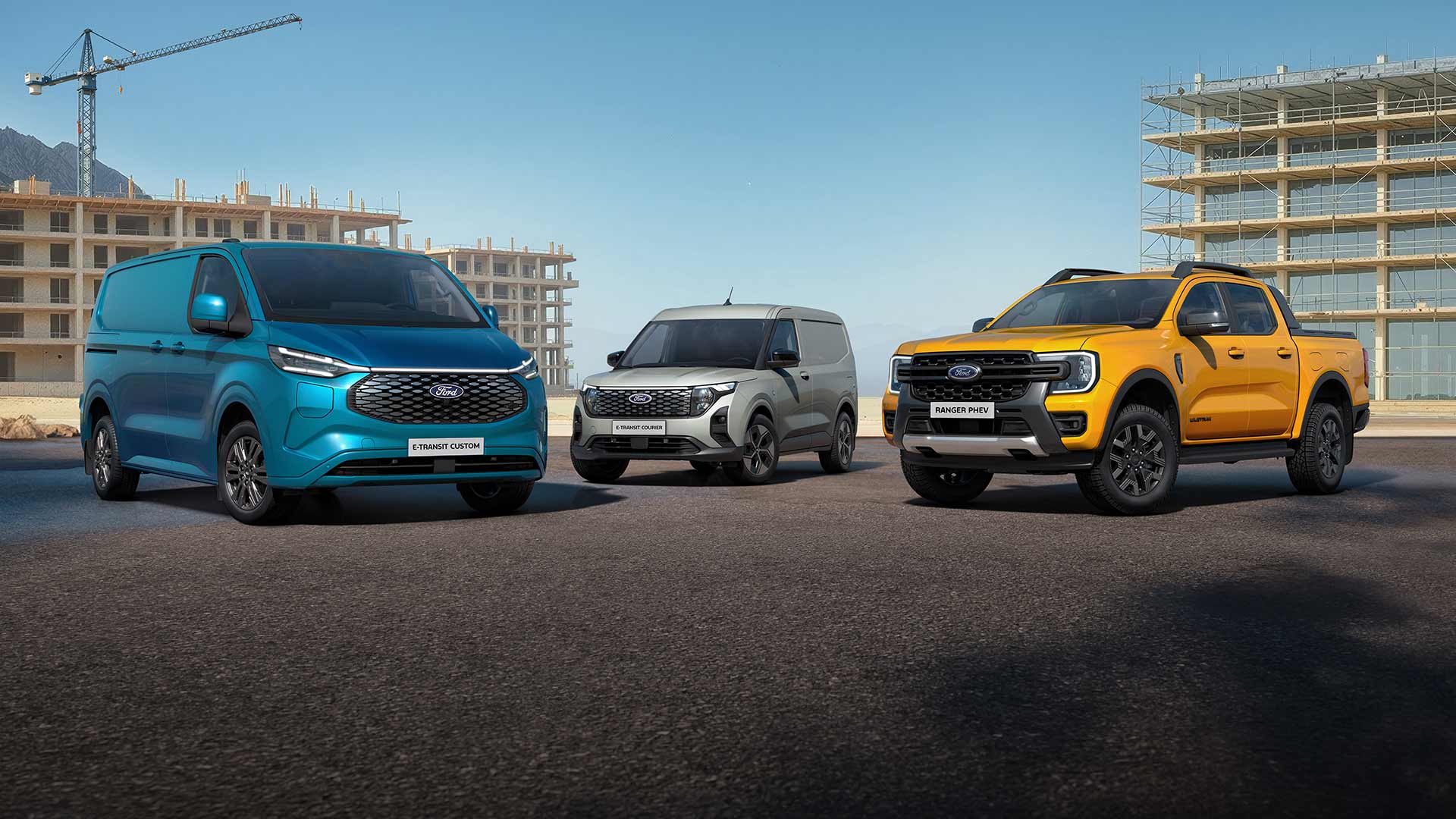 Un Ford E-Transit Custom, un Ford E-Transit Courier e un Ford Ranger PHEV parcheggiati su una strada.