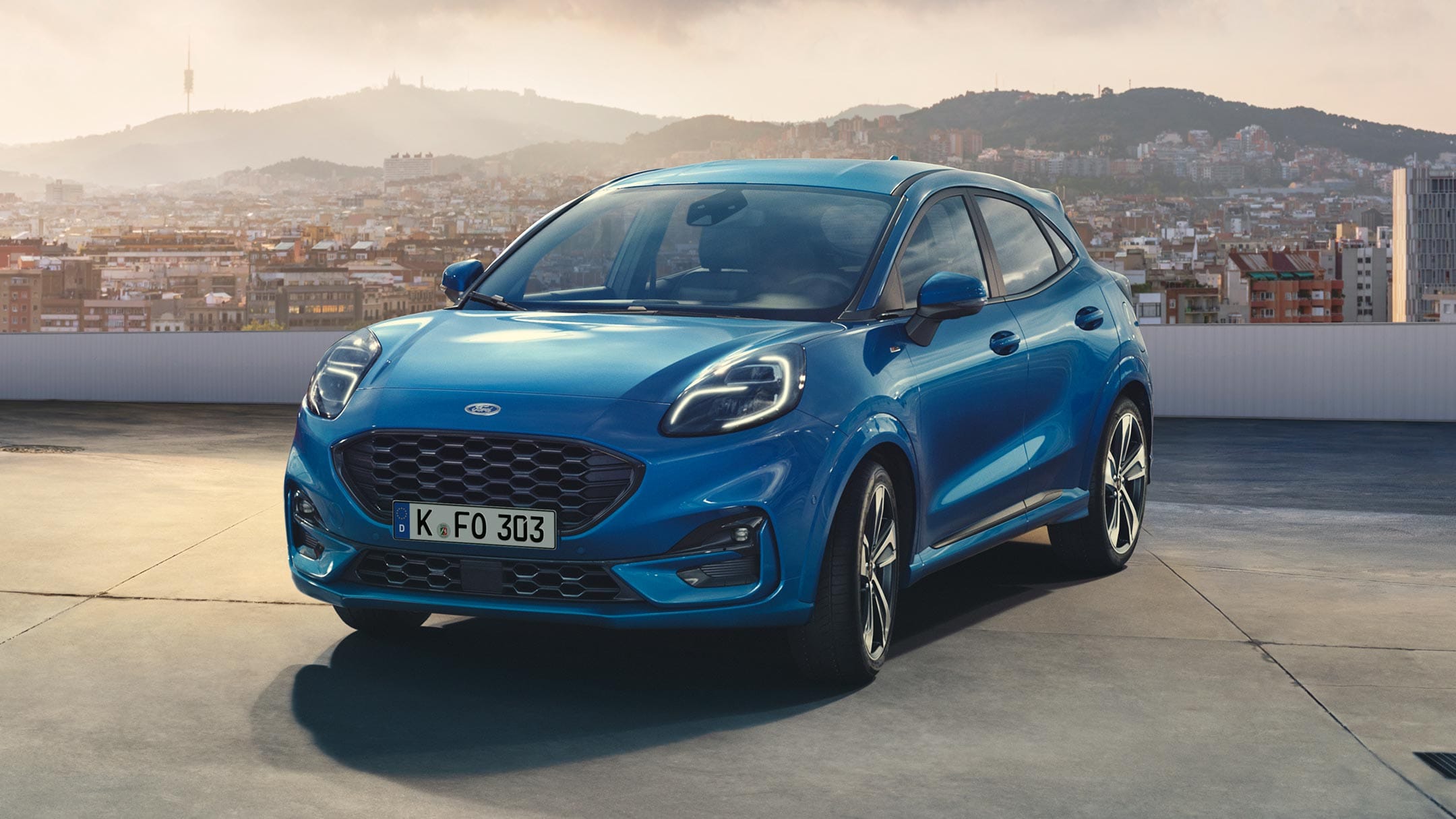 Ford Puma blu, vista anteriore ¾ in piedi su un parcheggio