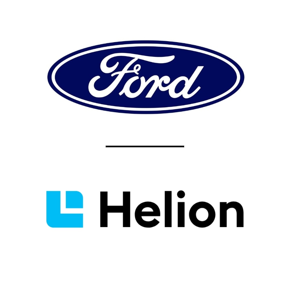Una donna collega un Ford Explorer elettrico blu a un impianto di ricarica.