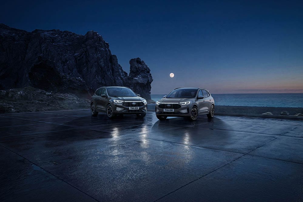 Due Ford Kuga parcheggiate di notte sulla costa sotto la luna piena.