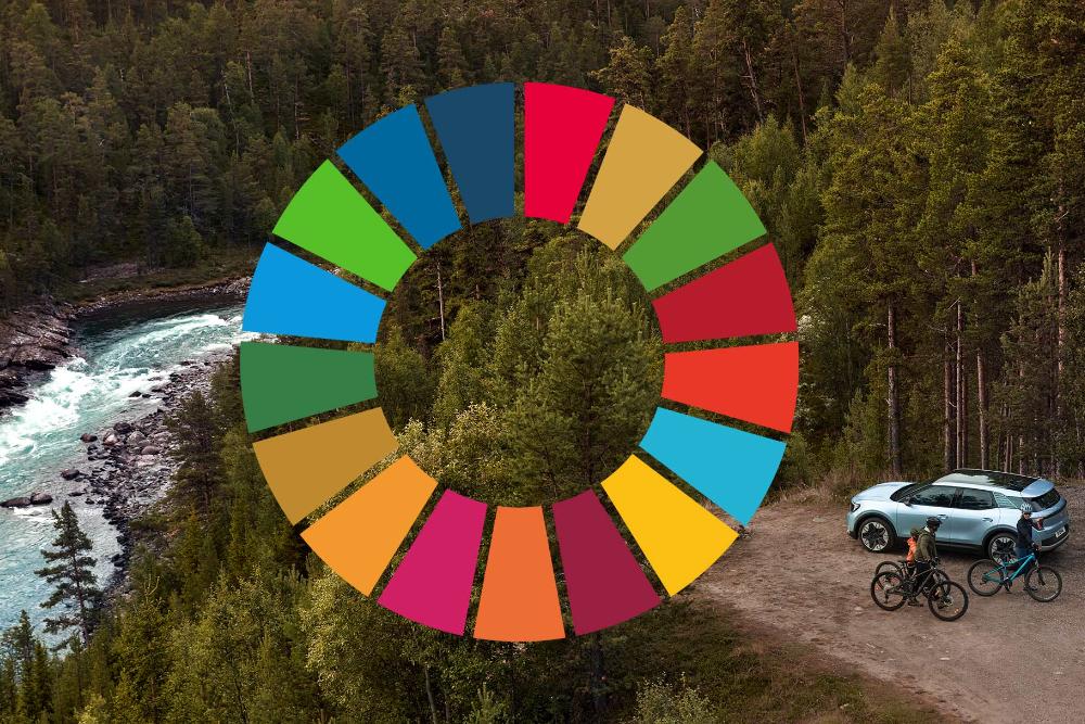 Nuovo Ford Explorer azzurro, vista aerea, parcheggiato in un bosco vicino alla riva di un fiume, con accanto due ciclisti