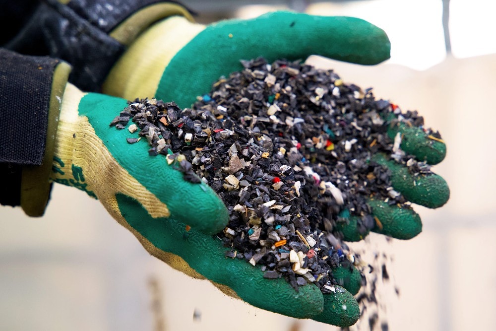 Due mani colme di granulato plastico riciclato