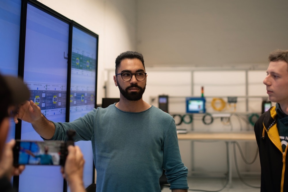 Un uomo spiega al proprio team un grafico visualizzato su uno schermo