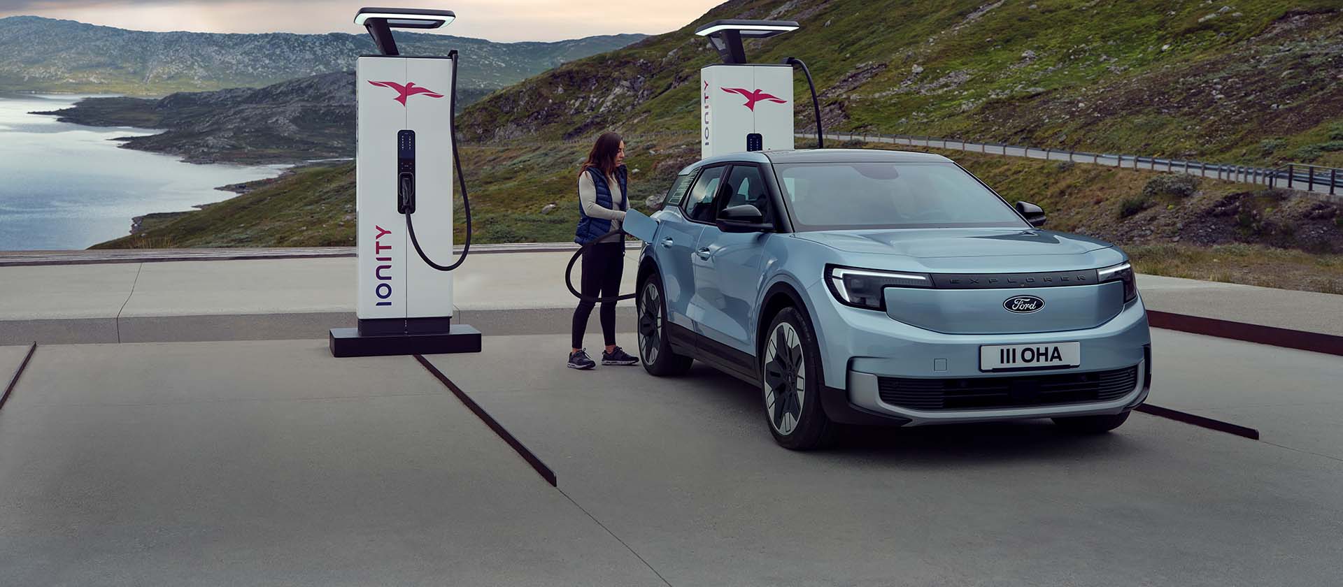A person charging the Ford Explorer® at sunset
