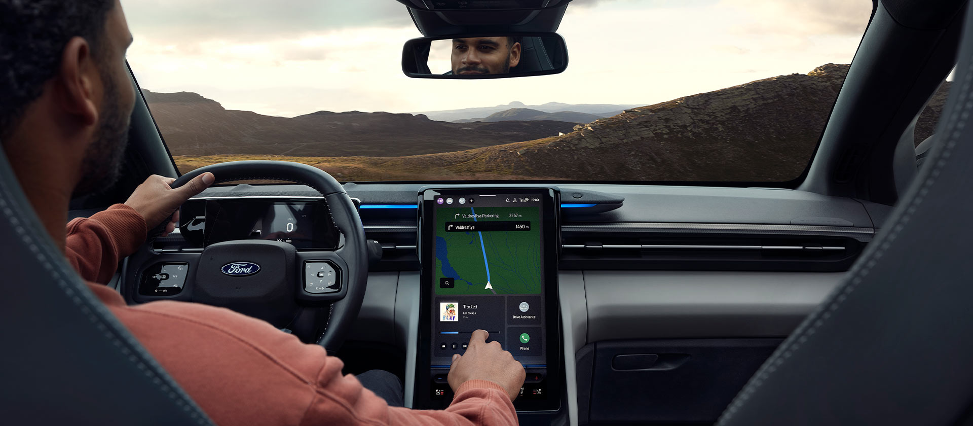 L’abitacolo di un veicolo elettrico Ford con strumenti di navigazione moderni per ottimizzare l’autonomia e la pianificazione del viaggio.