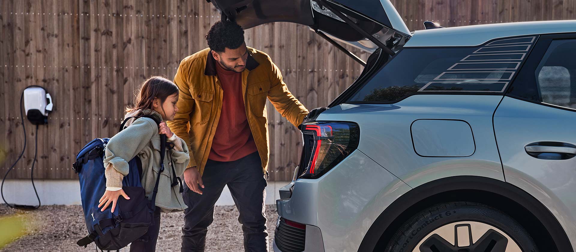 Una famiglia carica il bagagliaio di un Ford Explorer elettrico blu.