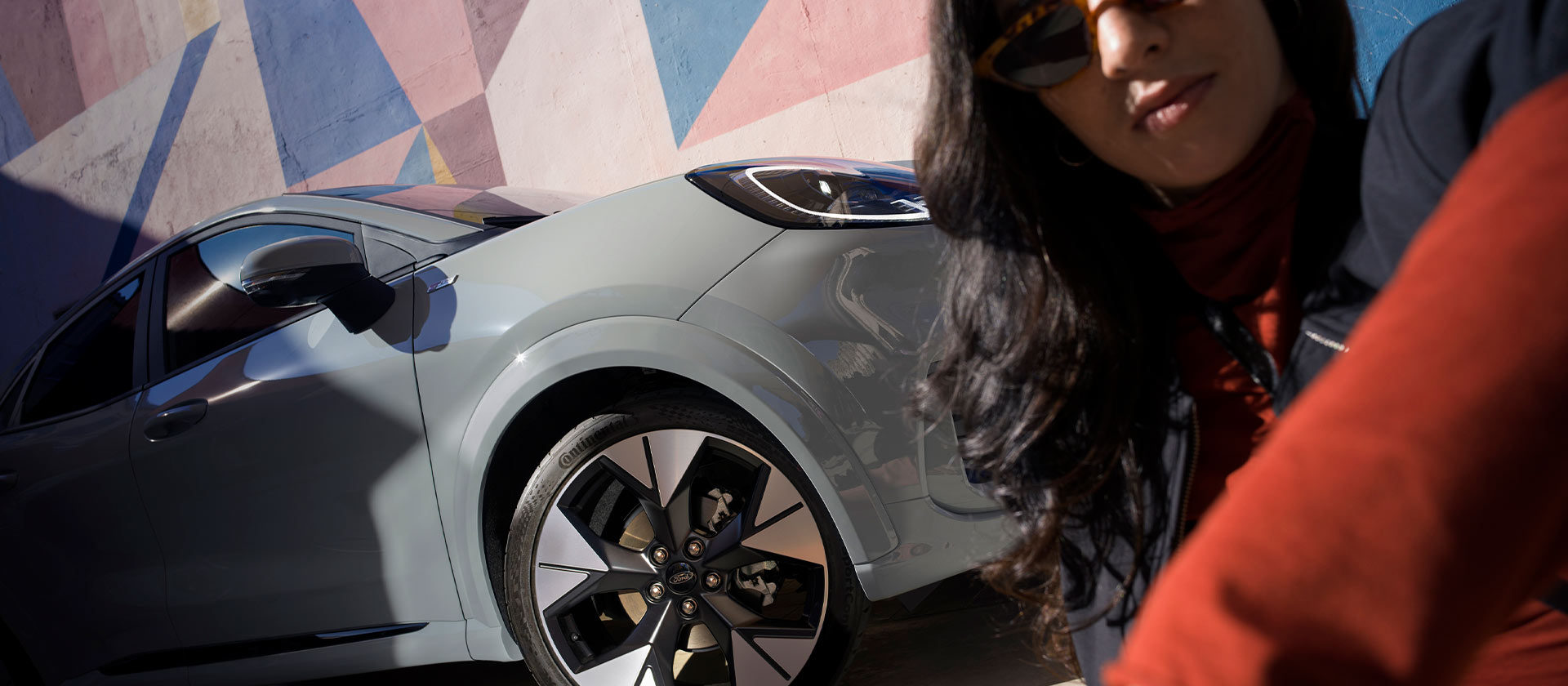 Una persona seduta accanto a una Ford Puma Mild Hybrid.