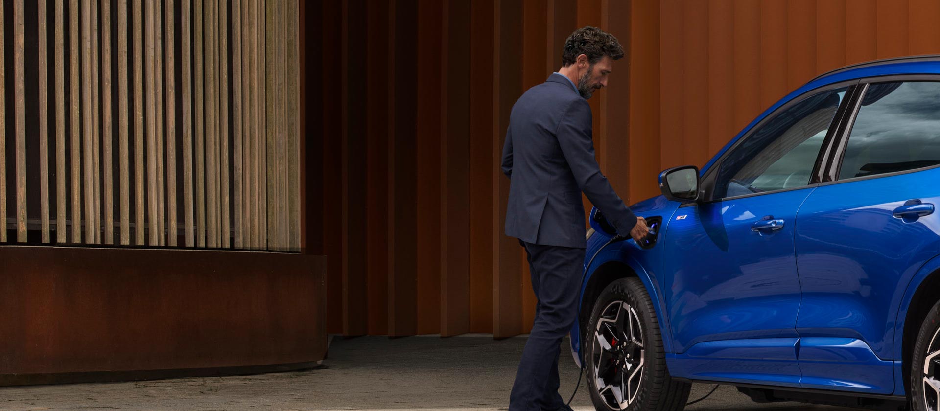 Una persona collega un veicolo Ford Plug-in-Hybrid a un impianto di ricarica.