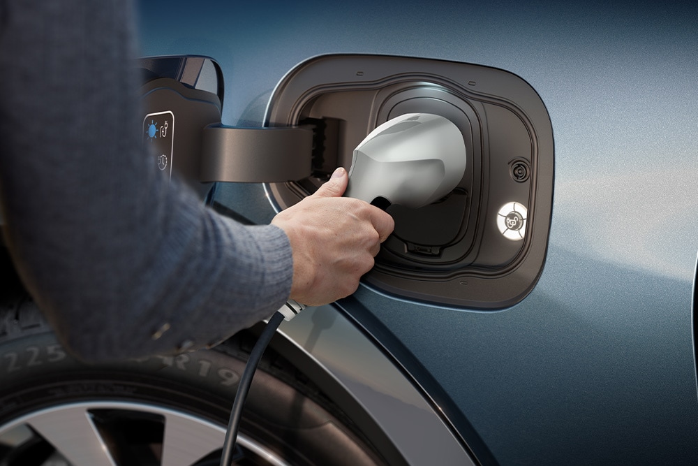 Primo piano di una persona che ricarica un veicolo elettrico Ford.