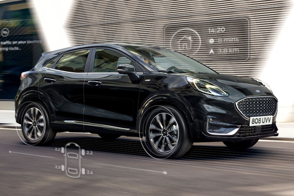 Ford Puma nera. Vista frontale a tre quarti davanti a un edificio moderno