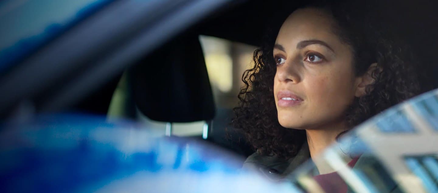 A person in the driver's seat of a Ford car