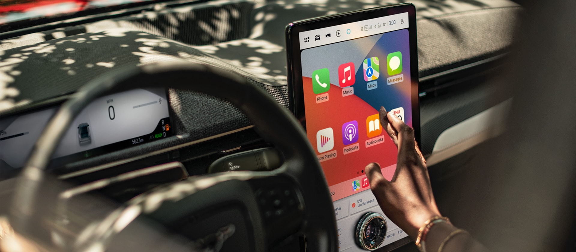 Il conducente di una Ford Mustang Mach-E che interagisce con il touchscreen SYNC 4 da 15.5 pollici con schermata Apple CarPlay.