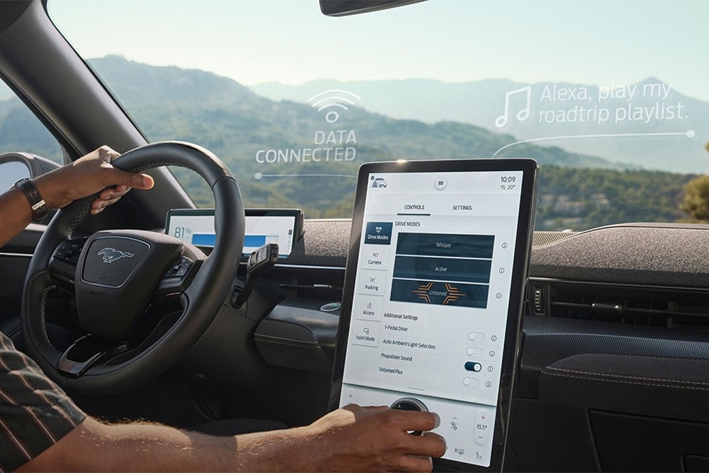 Vista ravvicinata di un conducente di una Ford Mustang Mach-E che interagisce con un grande touchscreen SYNC 4 da 15.5 pollici.