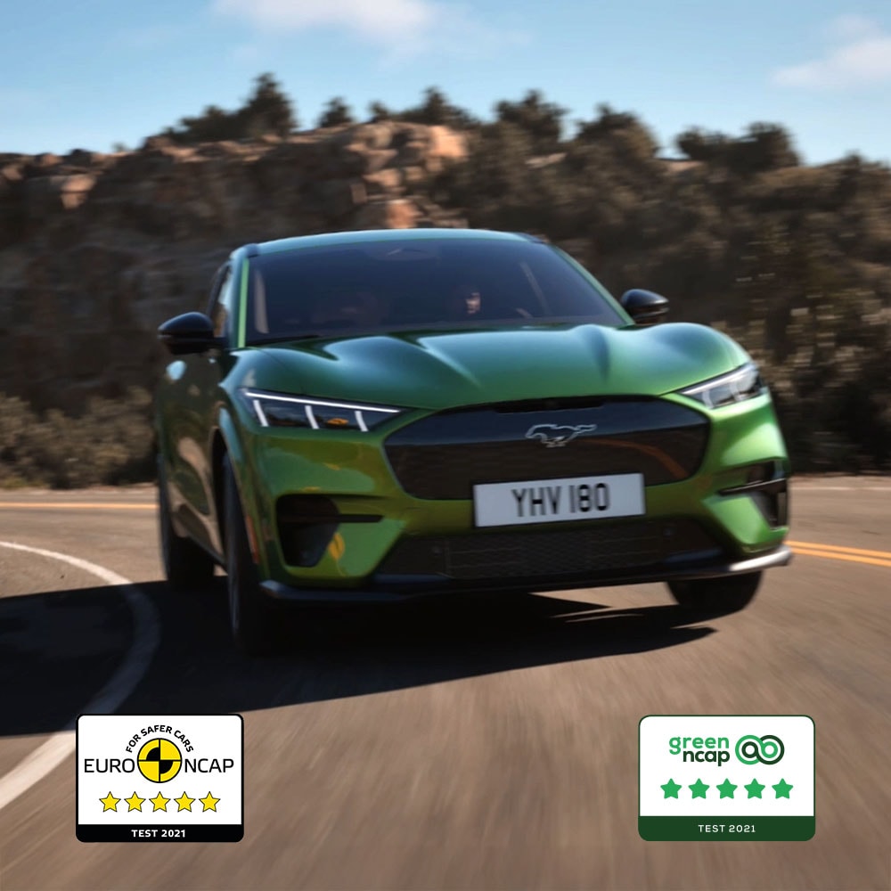Una Ford Mustang Mach-E GT verde in marcia su una strada di montagna.