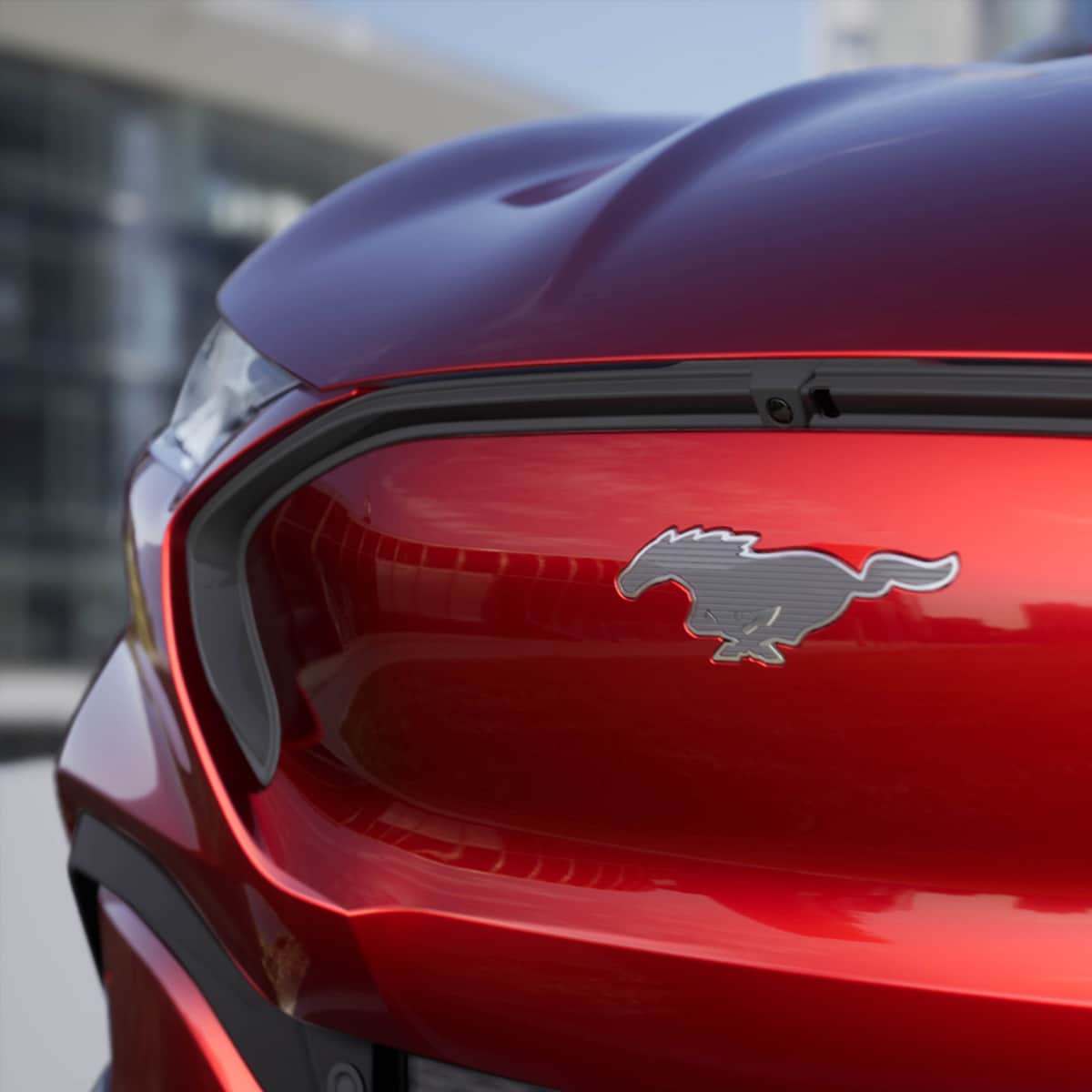 Ford Mustang Mach-E rossa. Vista dettagliata del frontale con pony Mustang argento