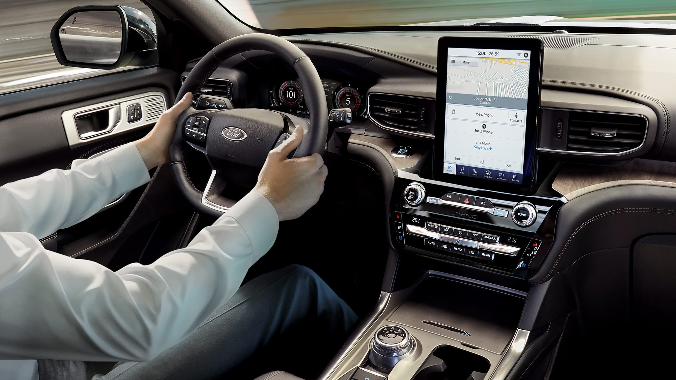 Ford Explorer Plug-in Hybrid. Interni. Vista dettagliata del volante e della console centrale con touchscreen. Mani sul volante