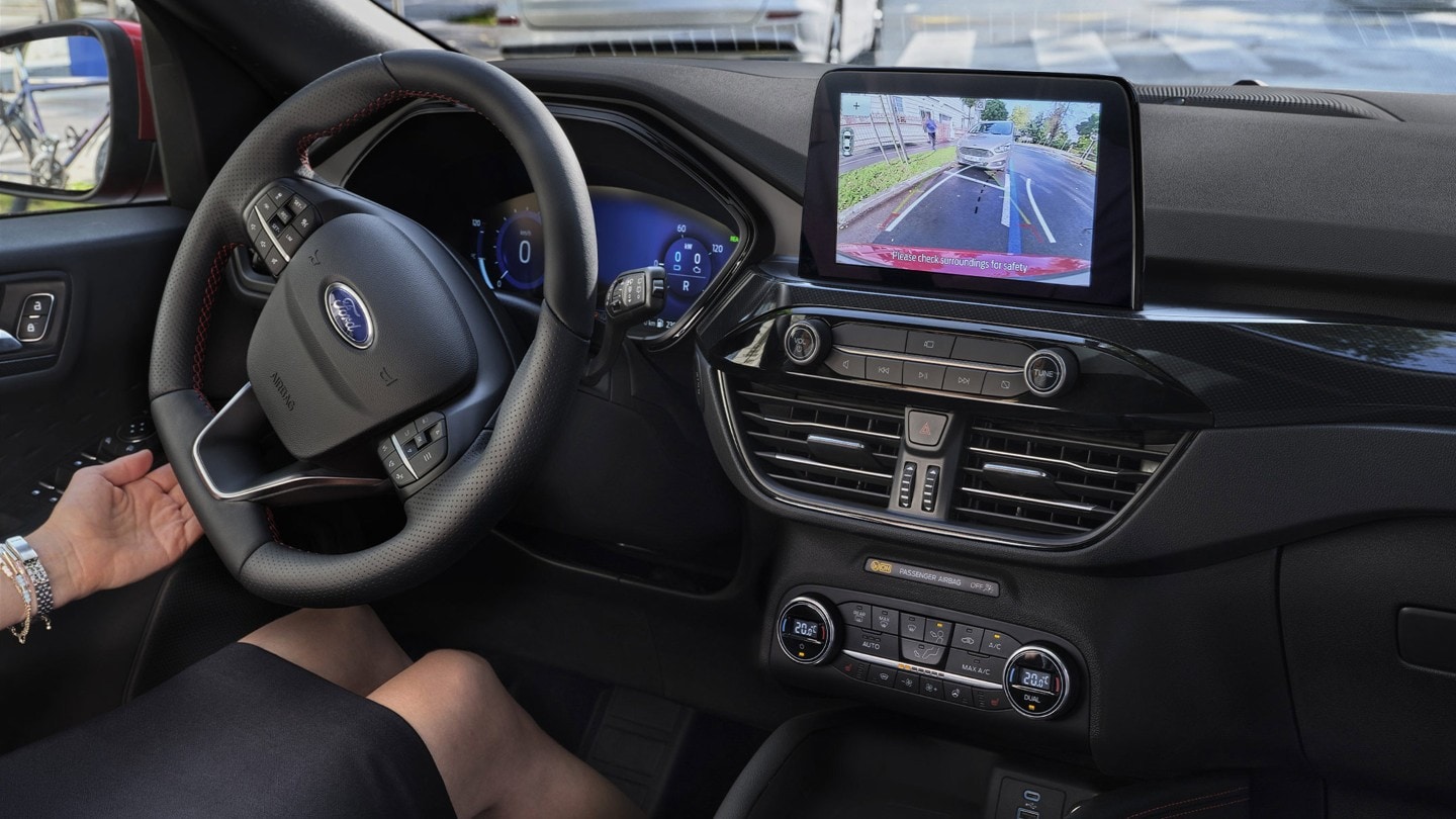 Ford Kuga. Abitacolo, vista dettagliata del volante e della console centrale con touchscreen e assistente di parcheggio attivo