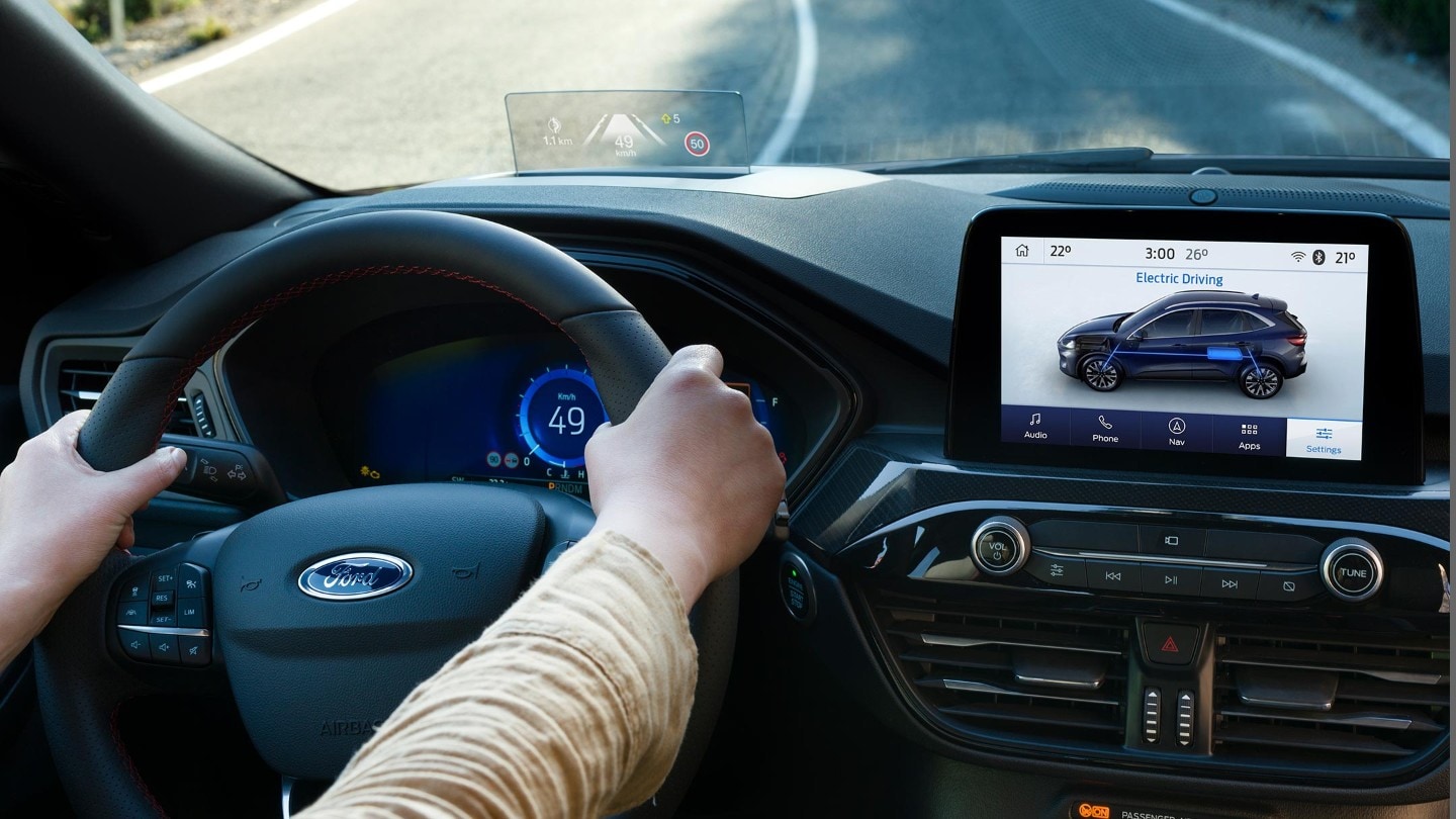 Ford Kuga. Abitacolo, vista dettagliata del volante e della console centrale con touchscreen. Mani sul volante