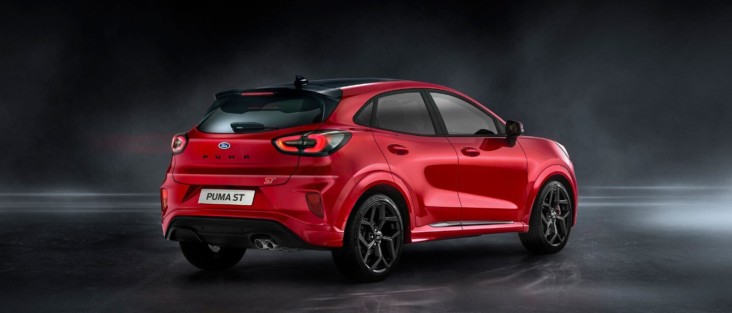 Ford Puma ST rossa, vista posteriore a tre quarti, parcheggiata in uno showroom buio