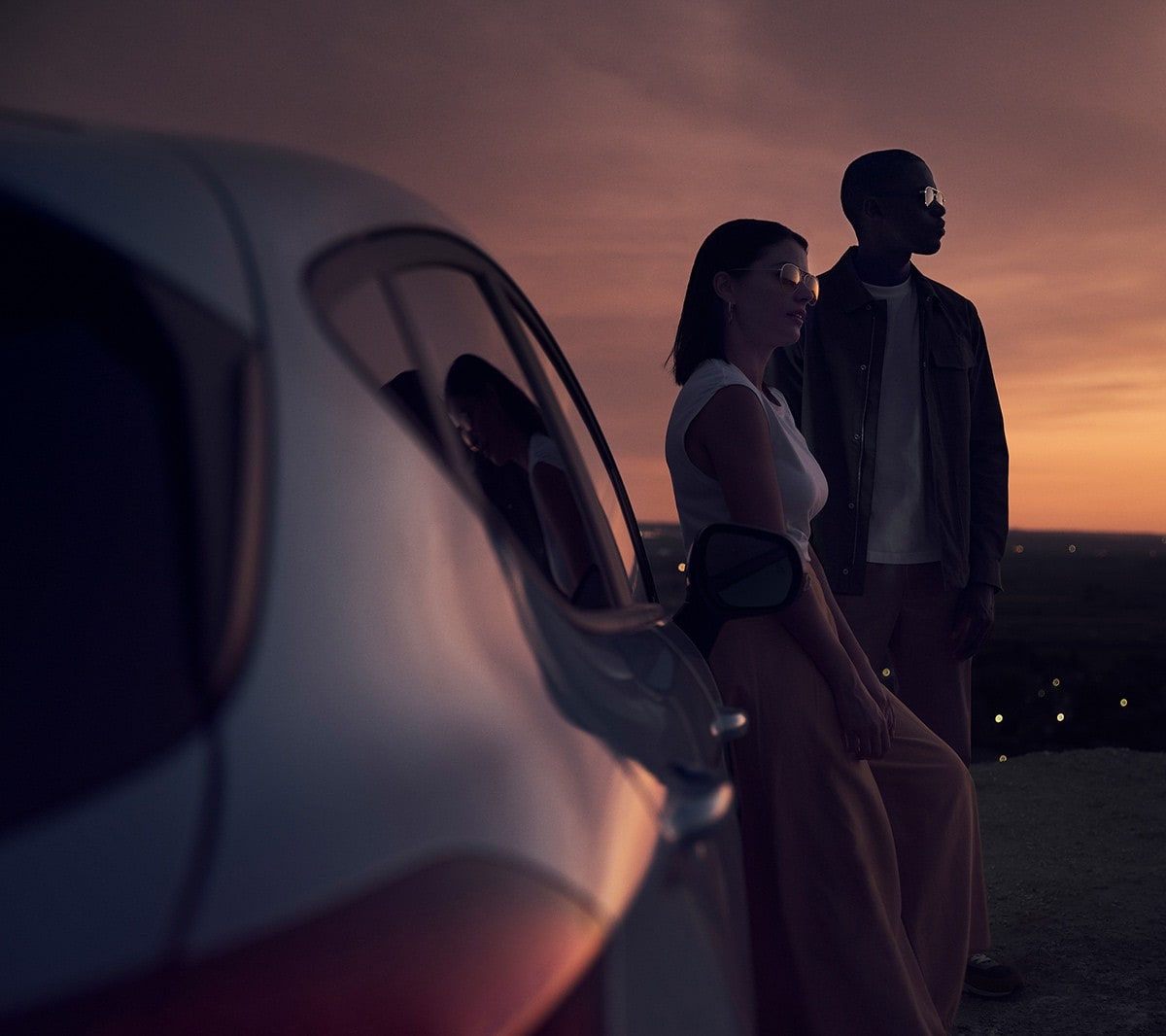 Ford Fiesta blu. Vista posteriore al tramonto con due persone sullo sfondo.