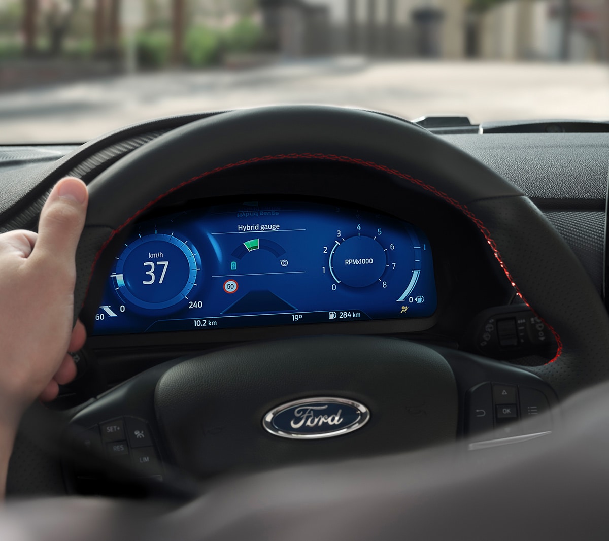 Ford Fiesta. Vista interna dettagliata del volante con quadro strumenti digitale sullo sfondo.