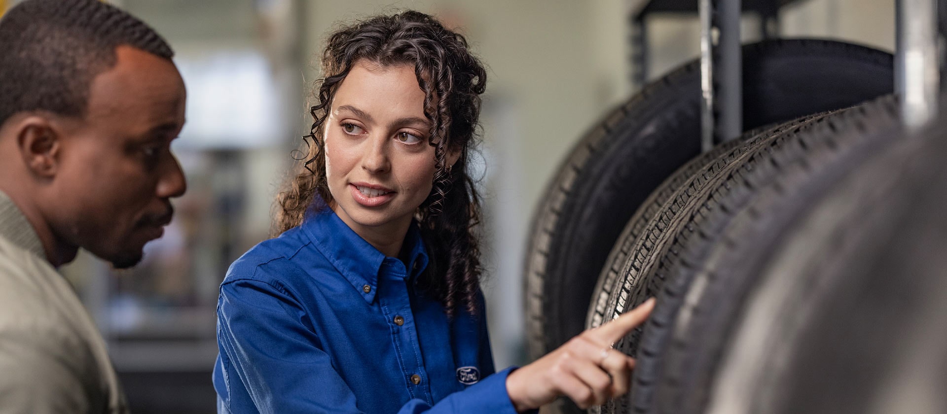Una specialista di riparazioni Ford consiglia a un cliente gli pneumatici nuovi della Fiesta.