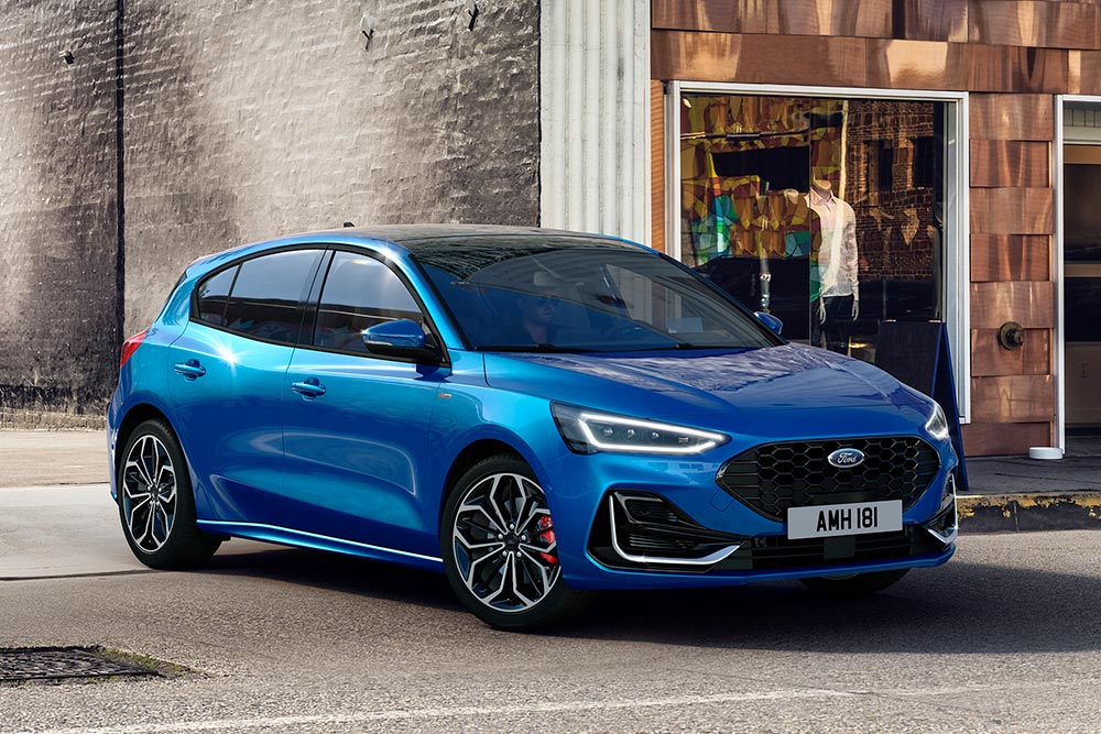 Una Ford Focus blu parcheggia in una strada urbana.