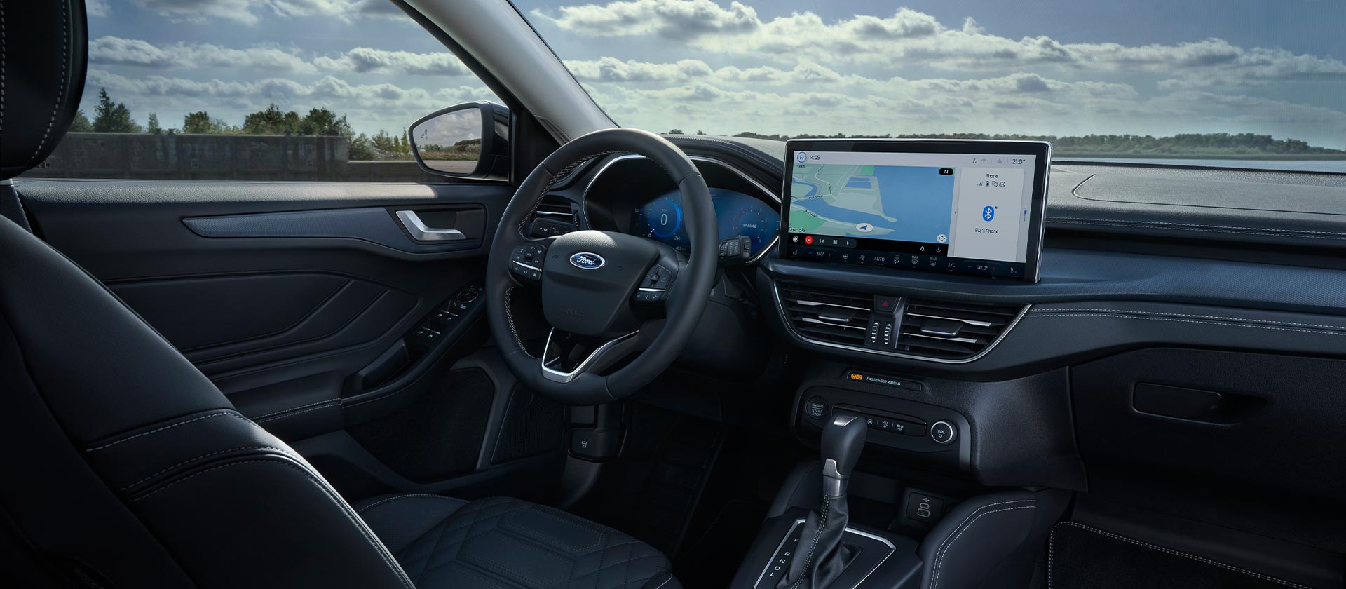 Vista interna di una Ford Focus  e del relativo cruscotto, schermo del sistema di infotainment con navigatore e volante.