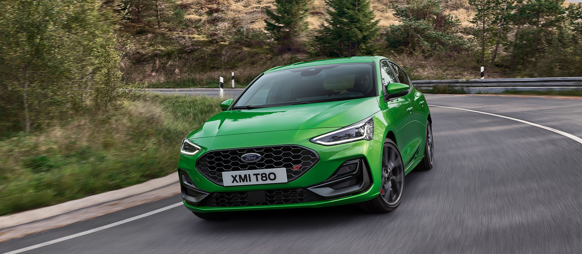 Una Ford Focus ST color Mean Green in curva su una strada pittoresca.