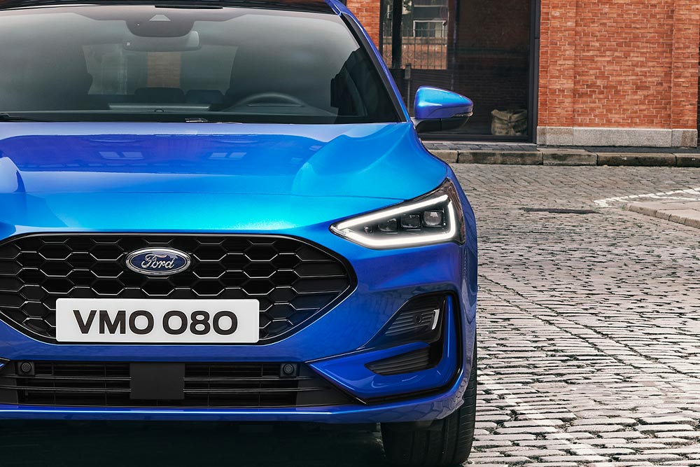 Vista frontale di una Ford Focus blu con evidenziazione dei fari e della calandra.