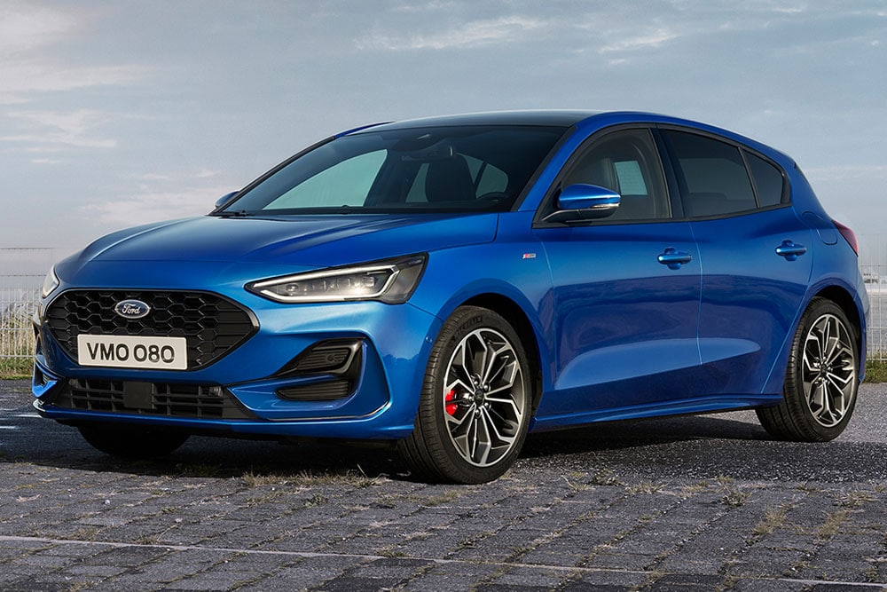 Una Ford Focus ST-Line modello hatchback blu con pinze frenanti rosse, parcheggiata su un fondo acciottolato.