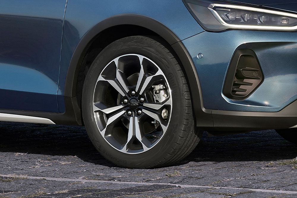 Vista ravvicinata dei cerchi in lega di una Ford Focus con verniciatura grigio scura e argentata.