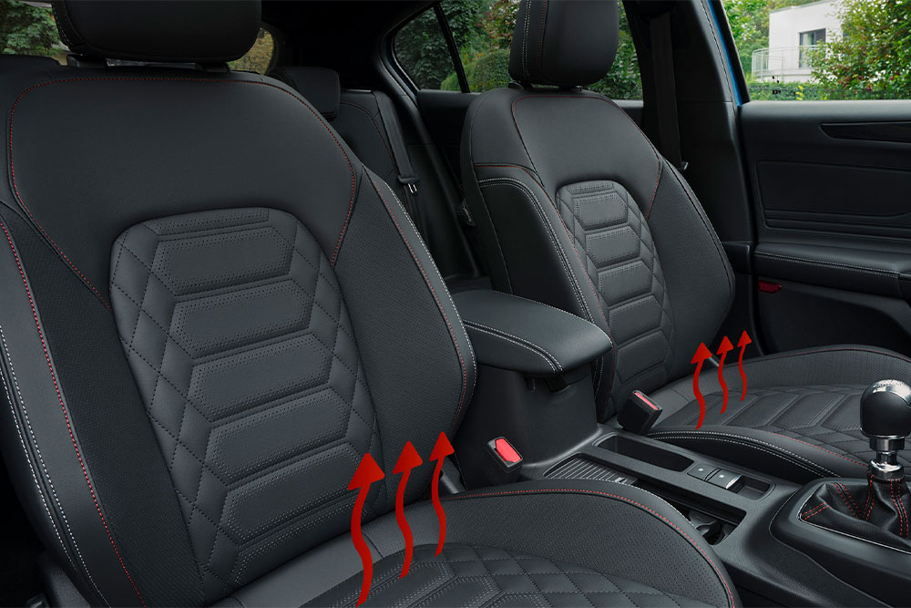 Frecce rosse che salgono verso l’alto dai sedili anteriori di una Ford Focus.Já