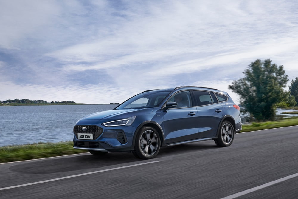 Una Ford Focus® Turnier blu in marcia lungo un lago.