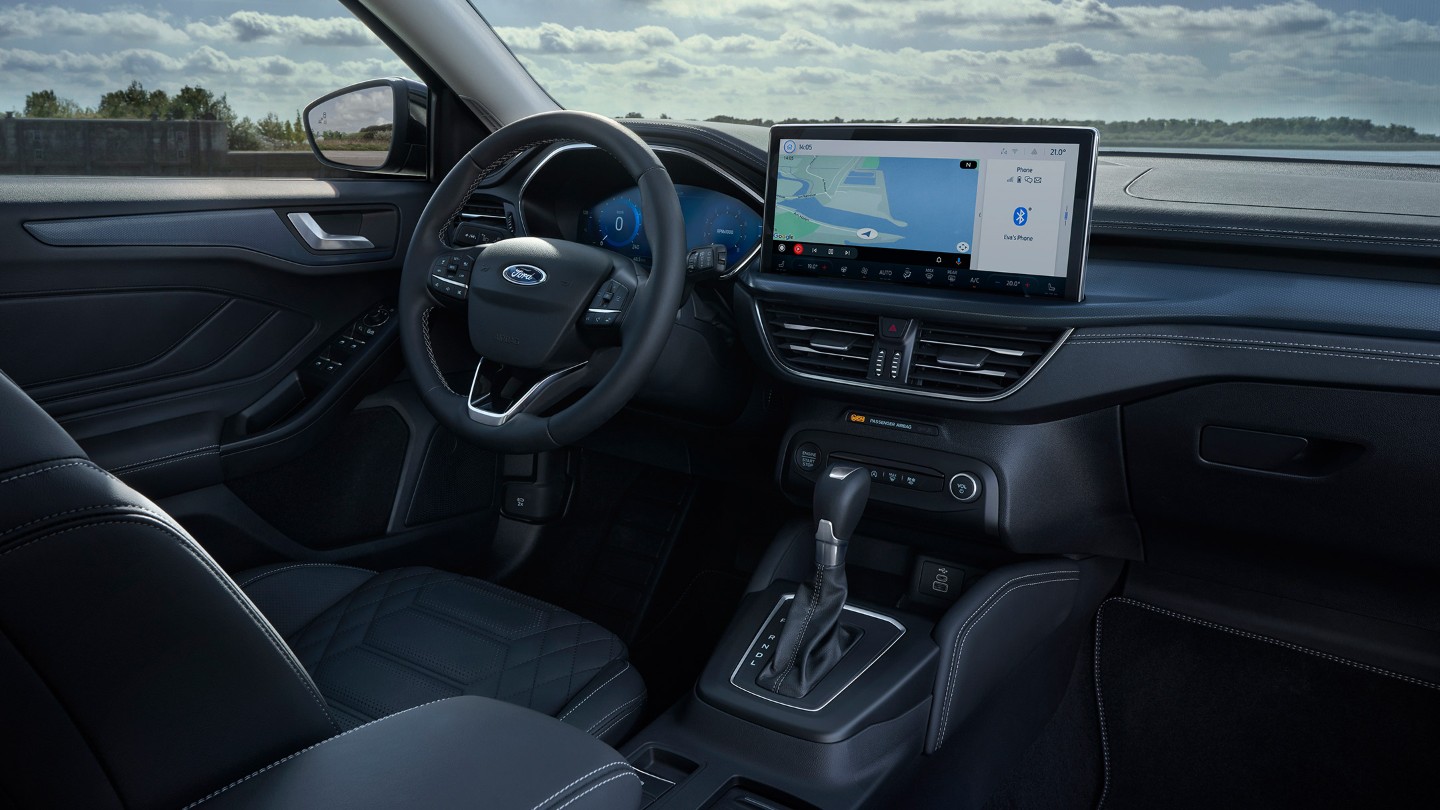 Ford Focus. Vista interna del cockpit con volante, pomello del cambio e Ford SYNC 4.
