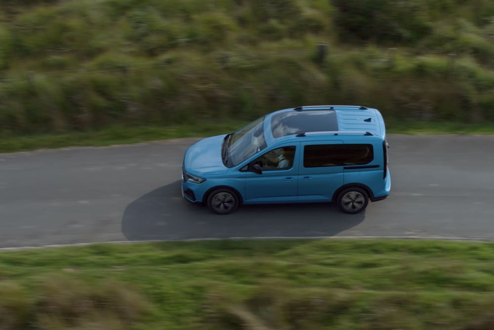 Ford Tourneo Connect azzurro, vista laterale dall’alto, in transito su una strada extraurbana