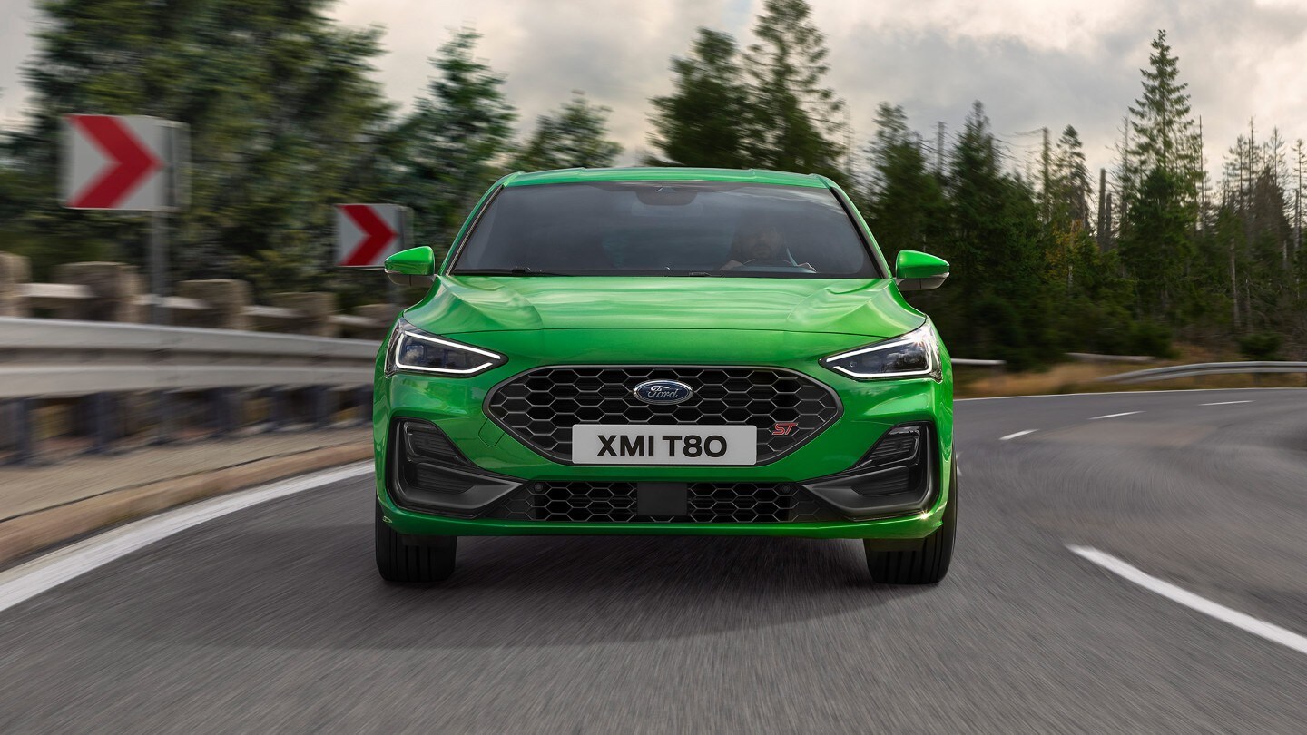 Ford Focus ST verde. Vista frontale, in marcia su una strada.