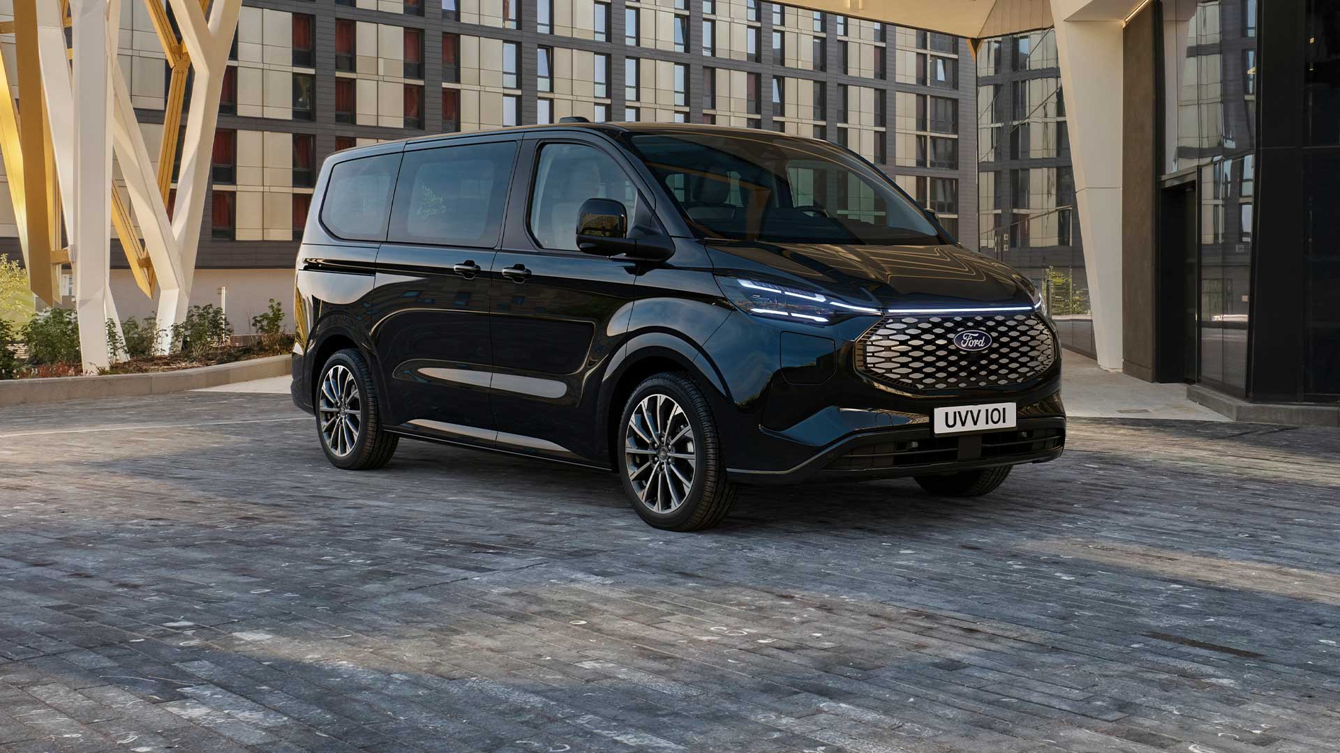 Ford E-Tourneo Custom nera parcheggiata davanti a un edificio moderno
