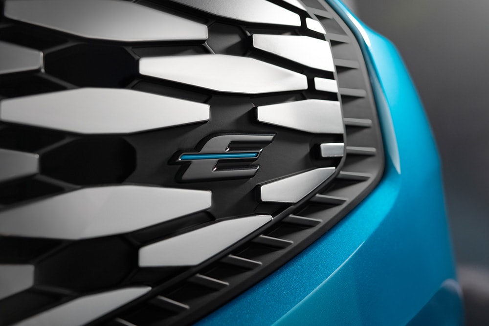 Primo piano della griglia della Ford E-Tourneo Custom con logo blu “E”, esclusivo per i veicoli elettrici Ford