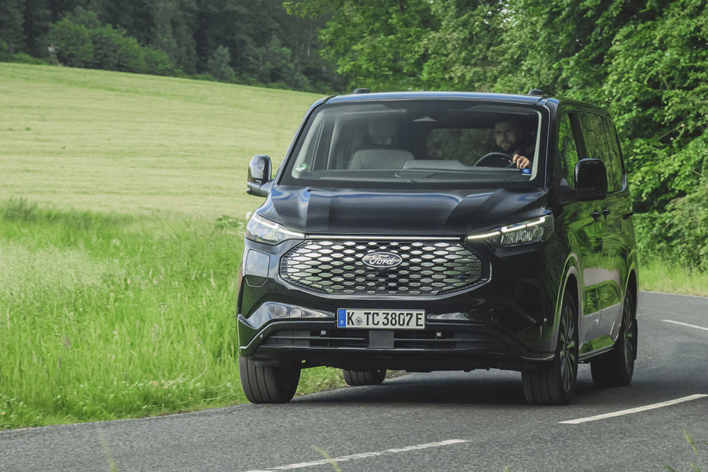 Ford E-Tourneo Custom nera che percorre una strada di campagna