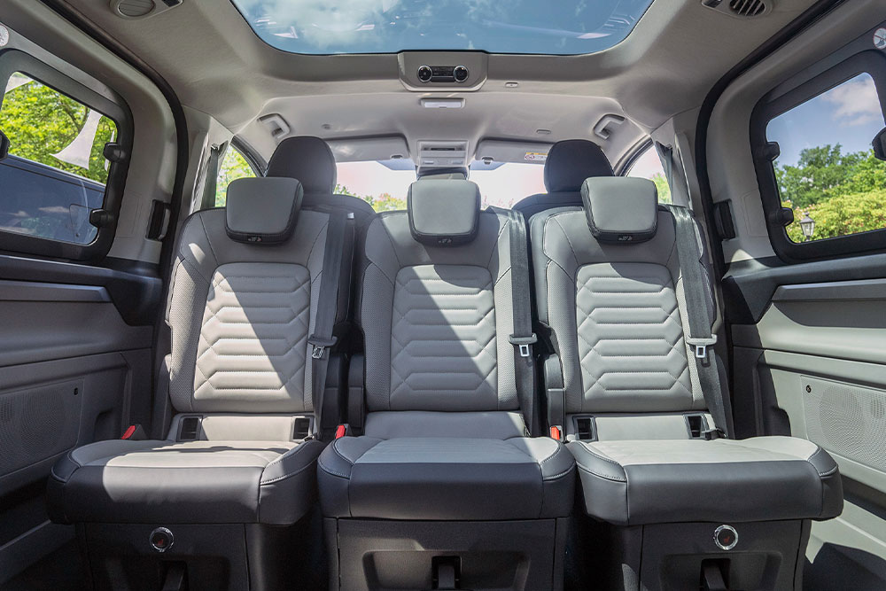 Interno di un veicolo con sedili posteriori grigi e tetto apribile