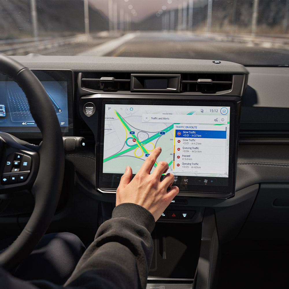 Ein Fahrer, der die Vernetzte Navigation auf dem digitalen Bildschirm eines Ford Puma Gen-E BlueCruise Edition nutzt.