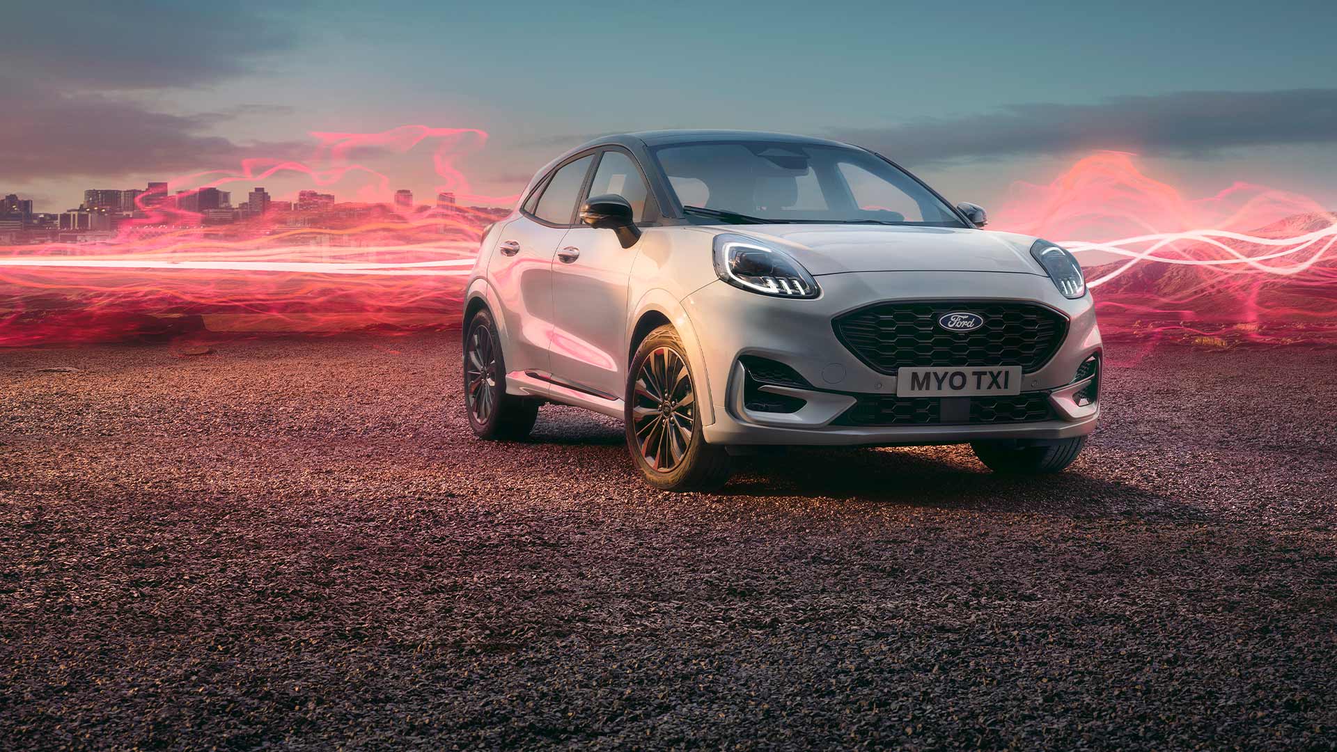 Una Ford Puma Sound Edition bianca parcheggiata, con onde sonore rosse sullo sfondo.