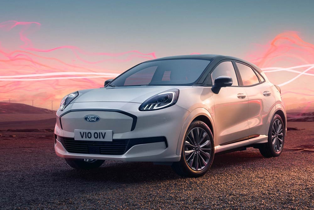Una Ford Puma Gen-E Sound Edition bianca parcheggiata, con onde sonore rosse sullo sfondo.