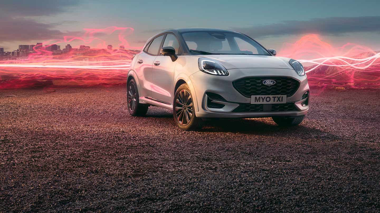 Una Ford Puma Sound Edition bianca parcheggiata, con onde sonore rosse sullo sfondo.