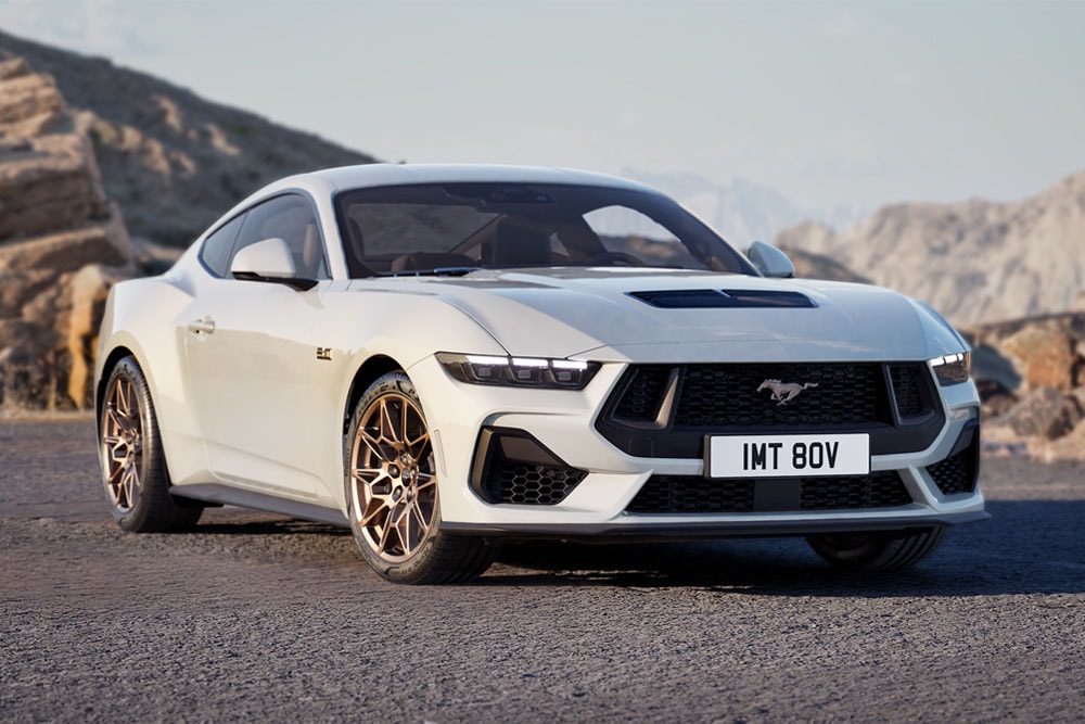 Ford Mustang GT Fastback con Bronze Pack in vernice Oxford White parcheggiato su una strada di montagna